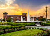 Thumbnail 19 of 30 - a large brick building with a fountain in front of it