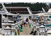 Thumbnail 20 of 25 - A couple walking on a dock with boats in the background.at Residence at Marina Bay, South Carolina, 29063