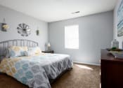 Thumbnail 4 of 27 - a bedroom with a bed and a dresser and a window