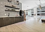 Thumbnail 30 of 47 - A modern kitchen with a dark wood floor and a black and white tiled backsplash. at The Palms 1101, Columbia, South Carolina