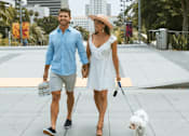 Thumbnail 11 of 47 - A man and woman walking a dog on a sidewalk. at The Palms 1101, Columbia, SC