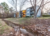 Thumbnail 2 of 27 - the stream in front of a house with a building in the background