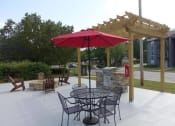 Thumbnail 6 of 27 - a patio with a table and chairs under a red umbrella