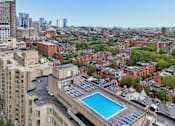 Thumbnail 8 of 22 - A rooftop pool is surrounded by a cityscape.
