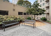 Thumbnail 6 of 50 - two park benches in front of an apartment building