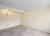 Thumbnail 37 of 50 - a living room with white walls and a carpet