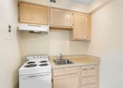 Thumbnail 32 of 50 - a kitchen with white appliances and wooden cabinets