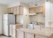 Thumbnail 33 of 50 - an empty kitchen with white appliances and wooden cabinets
