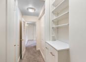 Thumbnail 36 of 50 - a walk in closet with white cabinets and a white counter