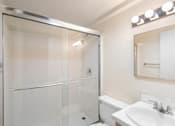 Thumbnail 38 of 50 - a bathroom with a shower and a sink and a toilet