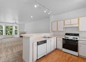 Thumbnail 24 of 29 - a kitchen with white cabinets and a stove and a sink at Oriel Apartments, Portland, 97225