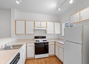 Thumbnail 13 of 29 - a kitchen with white cabinets and a stove and a refrigerator at Oriel Apartments, Portland, 97225