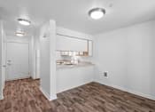 Thumbnail 37 of 50 - an empty living room and kitchen with white walls and wood floors at Summer Creek Apartments, Tigard