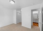 Thumbnail 34 of 50 - a bedroom with white walls and a door to a bathroom at Summer Creek Apartments, Oregon, 97223