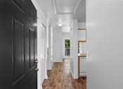 Thumbnail 10 of 50 - a hallway with black doors and white walls and a kitchen at Summer Creek Apartments, Tigard, OR, 97223