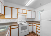 Thumbnail 21 of 50 - a kitchen with white appliances and wooden cabinets at Summer Creek Apartments, Tigard, OR