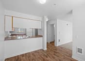 Thumbnail 28 of 50 - an empty living room and kitchen with white walls and wood floors at Summer Creek Apartments, Tigard, Oregon