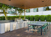 Thumbnail 6 of 47 - the outdoor kitchen has stainless steel appliances and a table with chairs