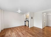 Thumbnail 37 of 47 - a living room and kitchen with wood floors and white walls