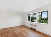 Thumbnail 27 of 47 - a living room with wood floors and a large window