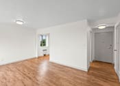 Thumbnail 43 of 47 - an empty living room with white walls and wood floors