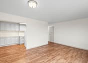 Thumbnail 40 of 47 - an empty living room with wood flooring and white walls