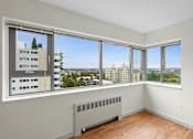 Thumbnail 35 of 47 - an empty room with windows and a radiator and a city view
