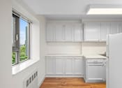 Thumbnail 42 of 47 - an empty kitchen with white cabinets and a window
