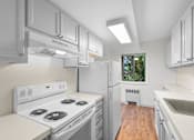 Thumbnail 24 of 47 - a white kitchen with white appliances and white cabinets