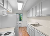 Thumbnail 41 of 47 - a white kitchen with white cabinets and white appliances