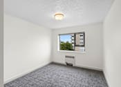 Thumbnail 28 of 47 - an empty living room with a window and white walls
