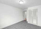 Thumbnail 34 of 47 - an empty room with white walls and a door to a bathroom