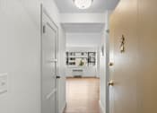 Thumbnail 30 of 47 - a view of a living room from a hallway with a door open