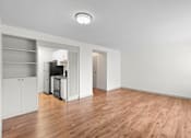 Thumbnail 31 of 47 - an empty living room with wood flooring and a kitchen