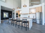 Thumbnail 14 of 27 - a kitchen with a large island and chairs at Sonder Fields in Happy Valley, OR