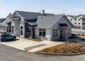 Thumbnail 13 of 27 - a building with a parking lot and cars in front of it at Sonder Fields in Happy Valley, OR