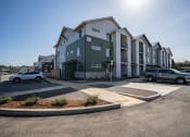 Thumbnail 1 of 27 - an apartment building with cars parked in a parking lot at Sonder Fields in Happy Valley, OR