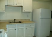 Thumbnail 15 of 17 - A kitchen with a sink and a refrigerator.