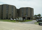 Thumbnail 3 of 17 - A Renovance Apartment complex with a parking lot in front.