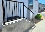 Thumbnail 16 of 19 - A black metal railing on a concrete staircase.