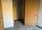 Thumbnail 113 of 115 - A room with a wooden door and a grey carpet.