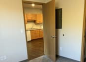 Thumbnail 112 of 115 - A room with a carpeted floor and a doorway leading to a kitchen.