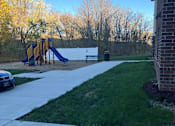 Thumbnail 107 of 115 - A playground with a yellow slide and a blue car parked in the driveway.