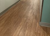 Thumbnail 106 of 115 - A long hallway with wood floors and white walls.
