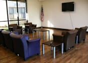 Thumbnail 8 of 17 - A room with a wooden floor and a television mounted on the wall.