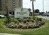 Thumbnail 2 of 17 - A sign for Renaissance Place, a senior living community, is surrounded by a flower bed.