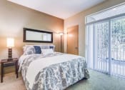 Thumbnail 10 of 30 - a bedroom with a bed and a sliding glass door at Madison Sierra Sun, Puyallup, WA