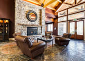 Thumbnail 21 of 30 - a living room with leather furniture and a stone fireplace at Madison Sierra Sun, Washington, 98374