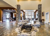 Thumbnail 18 of 30 - a waterfall in the center of a living room with a rock fountain at Madison Sierra Sun, Puyallup, Washington