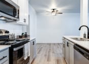 Thumbnail 13 of 30 - a kitchen with a sink and a stove and a ceiling fan at Madison Sierra Sun, Puyallup, 98374